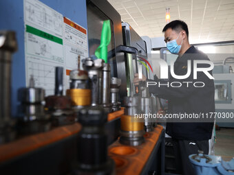 A worker produces metal parts at a workshop of a precision machinery manufacturing enterprise in Binzhou, China, on November 12, 2024. (