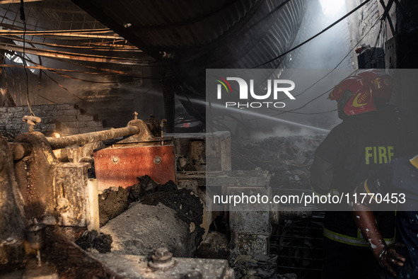 A firefighter tries to extinguish the fire at a shoe factory in the Shyampur area in Dhaka, Bangladesh, on November 12, 2024. 