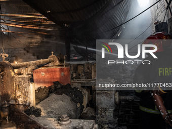 A firefighter tries to extinguish the fire at a shoe factory in the Shyampur area in Dhaka, Bangladesh, on November 12, 2024. (