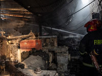 A firefighter tries to extinguish the fire at a shoe factory in the Shyampur area in Dhaka, Bangladesh, on November 12, 2024. (