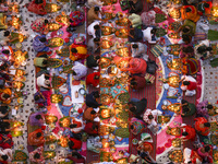 Hindu devotees sit together in front of oil lamps and candles and pray to Lokenath Brahmachari, a Hindu saint and philosopher, as they obser...