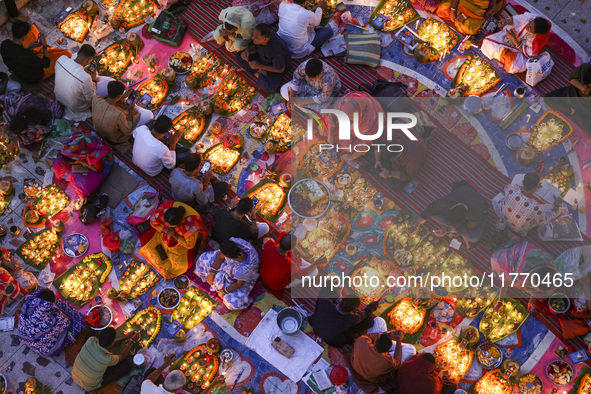 Hindu devotees sit together in front of oil lamps and candles and pray to Lokenath Brahmachari, a Hindu saint and philosopher, as they obser...