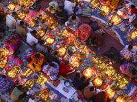 Hindu devotees sit together in front of oil lamps and candles and pray to Lokenath Brahmachari, a Hindu saint and philosopher, as they obser...