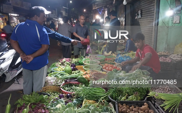 People buy vegetables at an evening market in Siliguri, India, on November 12, 2024. Vegetable and onion prices soar in the market. 