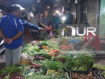 People buy vegetables at an evening market in Siliguri, India, on November 12, 2024. Vegetable and onion prices soar in the market. (