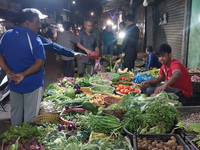 People buy vegetables at an evening market in Siliguri, India, on November 12, 2024. Vegetable and onion prices soar in the market. (