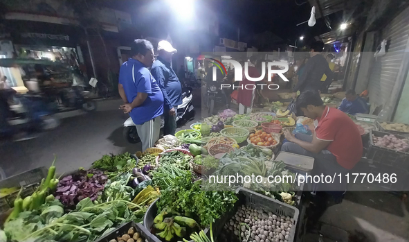 People buy vegetables at an evening market in Siliguri, India, on November 12, 2024. Vegetable and onion prices soar in the market. 