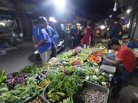 People buy vegetables at an evening market in Siliguri, India, on November 12, 2024. Vegetable and onion prices soar in the market. (