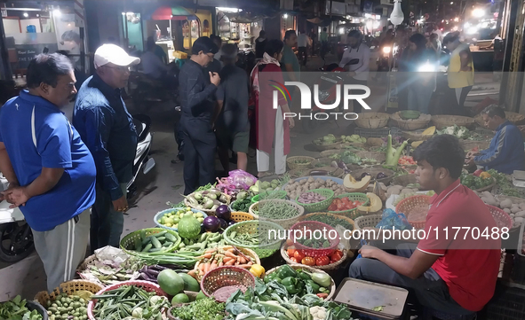 People buy vegetables at an evening market in Siliguri, India, on November 12, 2024. Vegetable and onion prices soar in the market. 