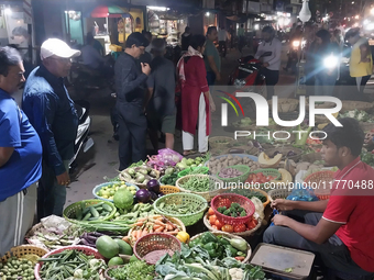 People buy vegetables at an evening market in Siliguri, India, on November 12, 2024. Vegetable and onion prices soar in the market. (