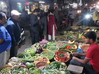 People buy vegetables at an evening market in Siliguri, India, on November 12, 2024. Vegetable and onion prices soar in the market. (