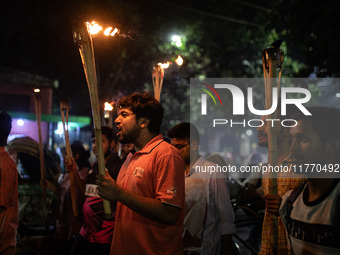 The Bangladesh Students Union holds a torch procession protesting the murder of a female ready-made garment worker and demanding justice at...