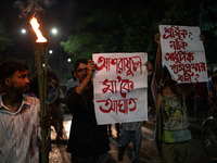 The Bangladesh Students Union holds a torch procession protesting the murder of a female ready-made garment worker and demanding justice at...