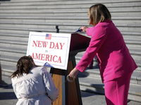 Aides affix a sign reading 'New Day in America' to a podium before a GOP press conference on the steps of the U.S. Capitol in Washington, D....