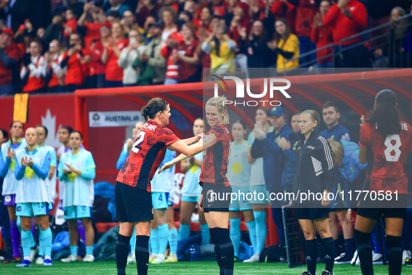 In Vancouver, Canada, on December 5, 2023, C. Sinclair, #12, passes the captain armband to S. Schmidt during the International Friendly Matc...