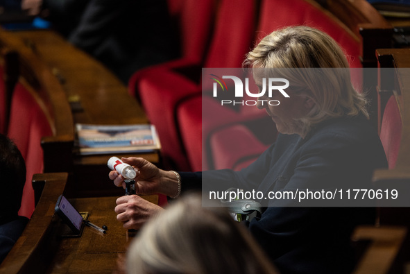 Rassemblement National leader Marine Le Pen refills her electronic cigarette between the benches of the Assemblee Nationale in Paris, France...