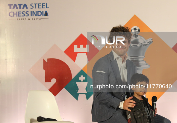 Norway's Magnus Carlsen poses with the world's youngest chess player, India's Anish Sarkar, during the 6th Tata Steel Chess India Rapid & Bl...