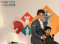 Norway's Magnus Carlsen poses with the world's youngest chess player, India's Anish Sarkar, during the 6th Tata Steel Chess India Rapid & Bl...