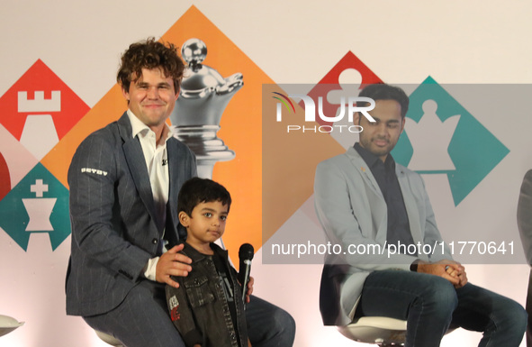 Norway's Magnus Carlsen poses with the world's youngest chess player, India's Anish Sarkar, during the 6th Tata Steel Chess India Rapid & Bl...