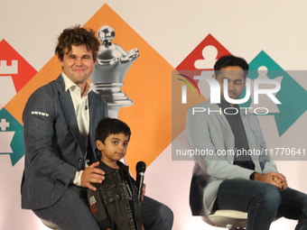 Norway's Magnus Carlsen poses with the world's youngest chess player, India's Anish Sarkar, during the 6th Tata Steel Chess India Rapid & Bl...