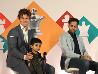 Norway's Magnus Carlsen poses with the world's youngest chess player, India's Anish Sarkar, during the 6th Tata Steel Chess India Rapid & Bl...