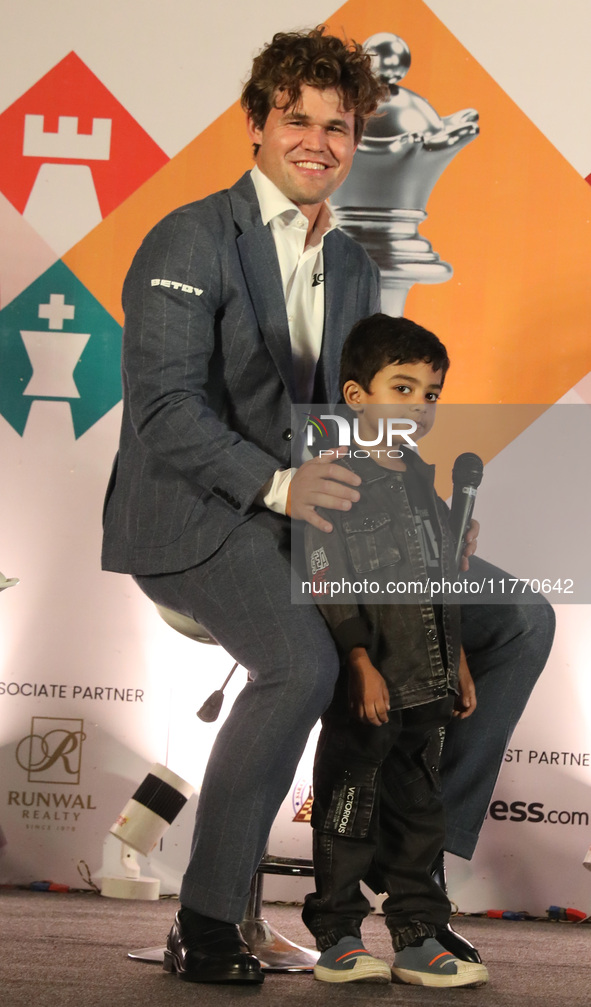 Norway's Magnus Carlsen poses with the world's youngest chess player, India's Anish Sarkar, during the 6th Tata Steel Chess India Rapid & Bl...