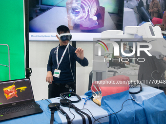 A fairgoer tries out VR surgery training, the medical technology at the Bonn University Hospital booth, at Medica 2024 at the Duesseldorf Ex...