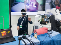 A fairgoer tries out VR surgery training, the medical technology at the Bonn University Hospital booth, at Medica 2024 at the Duesseldorf Ex...