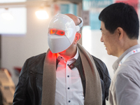 A fairgoer tries out a cosmetics LED face mask at Medica 2024 at the Duesseldorf Exhibition Center in Duesseldorf, Germany, on November 12,...