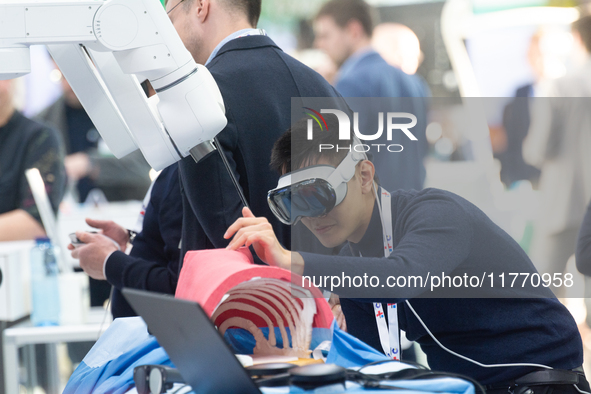 A fairgoer tries out VR surgery training, the medical technology at the Bonn University Hospital booth, at Medica 2024 at the Duesseldorf Ex...