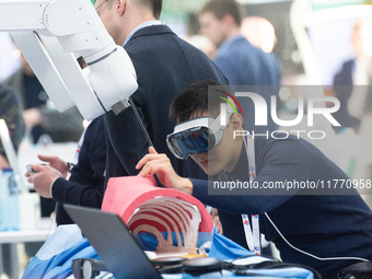 A fairgoer tries out VR surgery training, the medical technology at the Bonn University Hospital booth, at Medica 2024 at the Duesseldorf Ex...