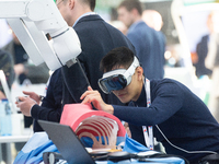 A fairgoer tries out VR surgery training, the medical technology at the Bonn University Hospital booth, at Medica 2024 at the Duesseldorf Ex...