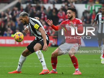 Joelinton of Newcastle United is under pressure from Alex Moreno of Nottingham Forest during the Premier League match between Nottingham For...