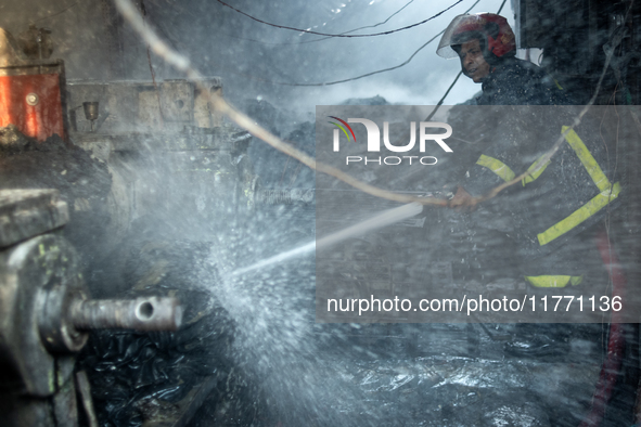 A firefighter works to extinguish flames at a burning shoe factory in a densely populated area of Dhaka, Bangladesh, on November 12, 2024. T...