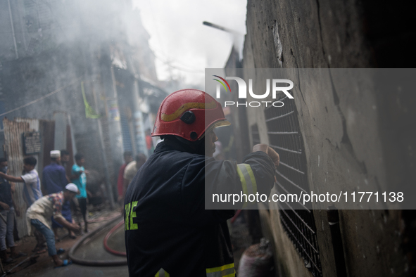 A firefighter works to extinguish flames at a burning shoe factory in a densely populated area of Dhaka, Bangladesh, on November 12, 2024. T...