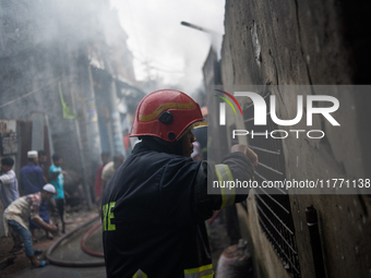 A firefighter works to extinguish flames at a burning shoe factory in a densely populated area of Dhaka, Bangladesh, on November 12, 2024. T...