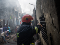 A firefighter works to extinguish flames at a burning shoe factory in a densely populated area of Dhaka, Bangladesh, on November 12, 2024. T...