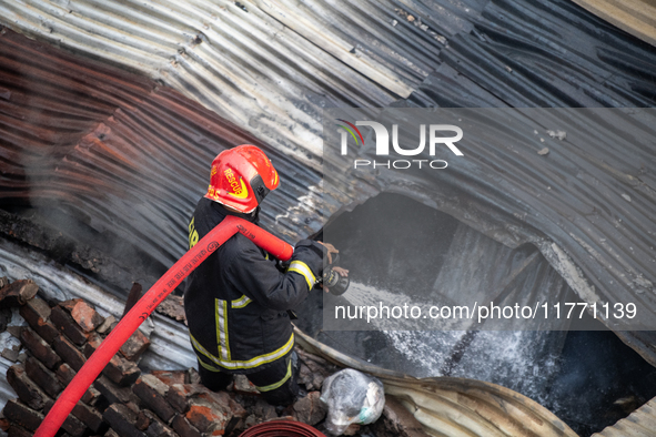 A firefighter works to extinguish flames at a burning shoe factory in a densely populated area of Dhaka, Bangladesh, on November 12, 2024. T...