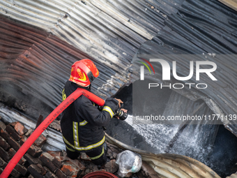 A firefighter works to extinguish flames at a burning shoe factory in a densely populated area of Dhaka, Bangladesh, on November 12, 2024. T...