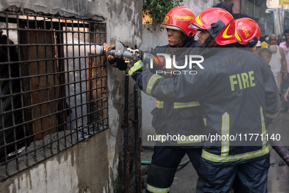 Firefighters work to extinguish flames at a burning shoe factory in a densely populated area of Dhaka, Bangladesh, on November 12, 2024. The...