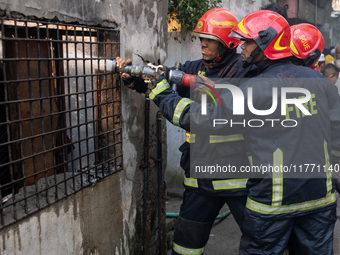 Firefighters work to extinguish flames at a burning shoe factory in a densely populated area of Dhaka, Bangladesh, on November 12, 2024. The...