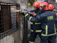 Firefighters work to extinguish flames at a burning shoe factory in a densely populated area of Dhaka, Bangladesh, on November 12, 2024. The...