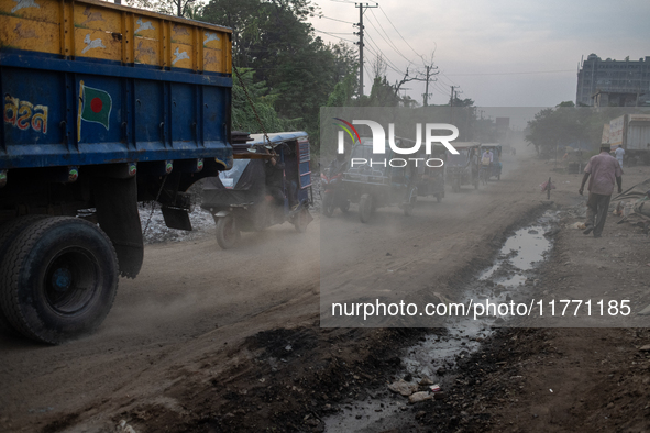 People move through a dusty, busy road in Dhaka, Bangladesh, on November 12, 2024. Dhaka, the overcrowded capital city, ranks 17th among cit...