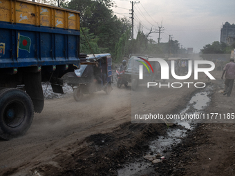 People move through a dusty, busy road in Dhaka, Bangladesh, on November 12, 2024. Dhaka, the overcrowded capital city, ranks 17th among cit...