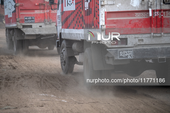 People move through a dusty, busy road in Dhaka, Bangladesh, on November 12, 2024. Dhaka, the overcrowded capital city, ranks 17th among cit...