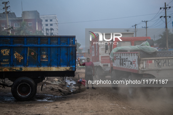 People move through a dusty, busy road in Dhaka, Bangladesh, on November 12, 2024. Dhaka, the overcrowded capital city, ranks 17th among cit...