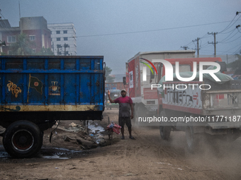 People move through a dusty, busy road in Dhaka, Bangladesh, on November 12, 2024. Dhaka, the overcrowded capital city, ranks 17th among cit...