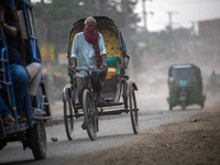 People move through a dusty, busy road in Dhaka, Bangladesh, on November 12, 2024. Dhaka, the overcrowded capital city, ranks 17th among cit...