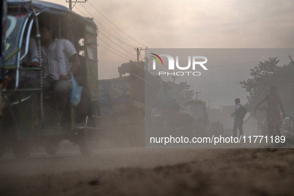 People move through a dusty, busy road in Dhaka, Bangladesh, on November 12, 2024. Dhaka, the overcrowded capital city, ranks 17th among cit...