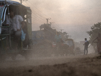 People move through a dusty, busy road in Dhaka, Bangladesh, on November 12, 2024. Dhaka, the overcrowded capital city, ranks 17th among cit...